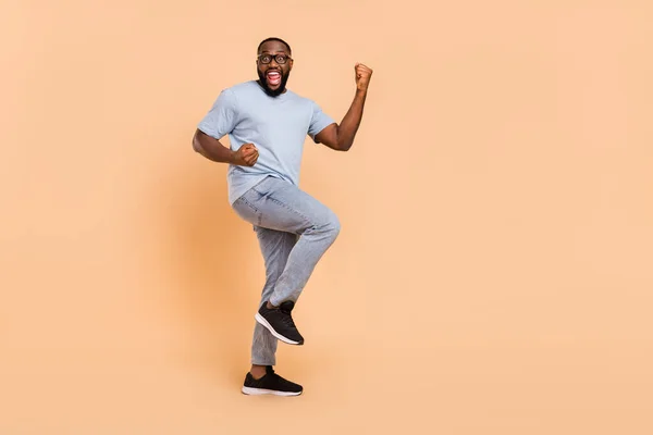 Full body photo of cool tisíciletý vousáč chlap křičet nosit brýle tričko džíny obuv izolované na béžové barvy pozadí — Stock fotografie