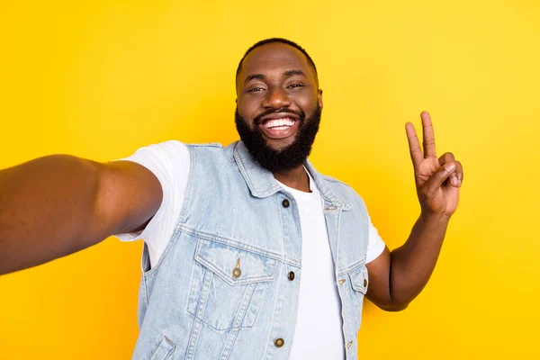 Self-portrait of attractive cheerful funky guy good mood showing v-sign isolated over vibrant yellow color background — Stock Photo, Image