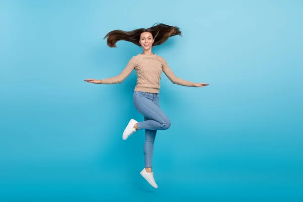 Foto de positivo inspirado despreocupado alegre señora salto viento soplo pelo desgaste beige suéter aislado color azul fondo —  Fotos de Stock