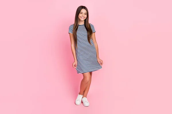 Photo of shiny charming girl dressed striped dress walking smiling isolated pink color background — Stock Photo, Image
