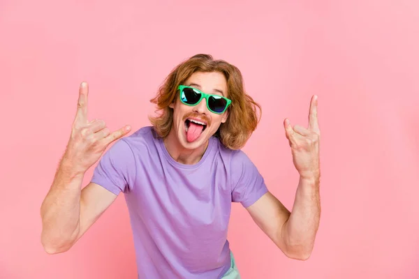 Porträtt av attraktiva glada galen kille visar horn symbol grimacing ha kul isolerad på rosa pastell färg bakgrund — Stockfoto