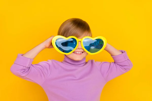Ritratto di affascinante buon umore piccolo uomo indossare divertenti enormi bicchieri a forma di cuore isolato su sfondo di colore giallo — Foto Stock
