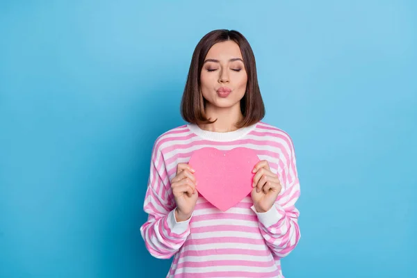 Foto de flerte morena milenar senhora segurar coração golpe beijo desgaste camisa rosa isolado no fundo de cor azul — Fotografia de Stock