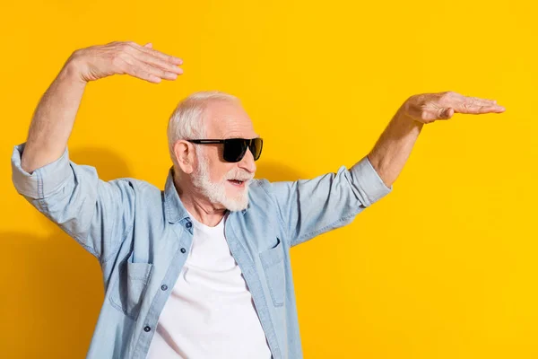 Retrato de atraente alegre homem de cabelos grisalhos dançando passatempo tempo livre se divertindo isolado sobre fundo de cor amarelo brilhante — Fotografia de Stock