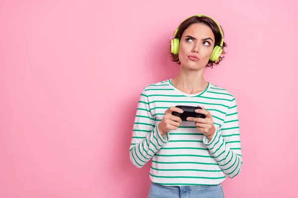 Foto van trieste millennial bob hairdo dame playstation kijken lege ruimte dragen hoofdtelefoon wit shirt geïsoleerd op roze kleur achtergrond — Stockfoto