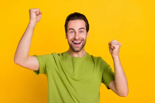 Foto van hooray brunet kapsel jonge man schreeuwen dragen groen t-shirt geïsoleerd op levendige gele kleur achtergrond — Stockfoto