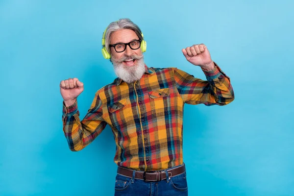 Foto von glücklichen Rentner tragen kariertes Hemd Brille genießen Musik tanzen Fäuste isoliert blaue Farbe Hintergrund — Stockfoto