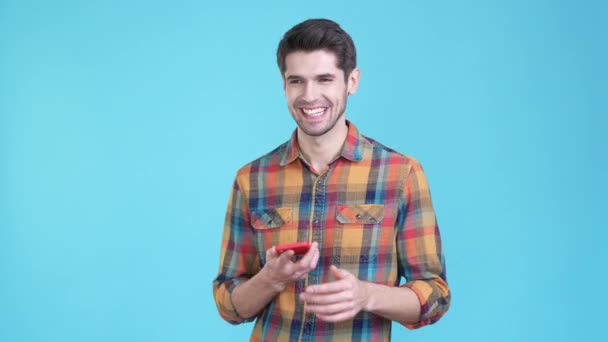 Millennial guy gebruik gadget tell zeggen nieuws geïsoleerde blauwe kleur achtergrond — Stockvideo