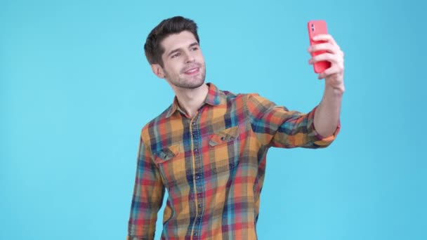 Guy Influencer κάνουν selfie σύμβολα προτείνουμε απομονωμένο φόντο μπλε χρώμα — Αρχείο Βίντεο