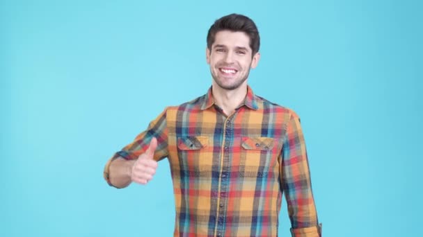 Guy promotor hacer anuncios símbolo de pulgar hacia arriba aislado fondo de color azul — Vídeo de stock