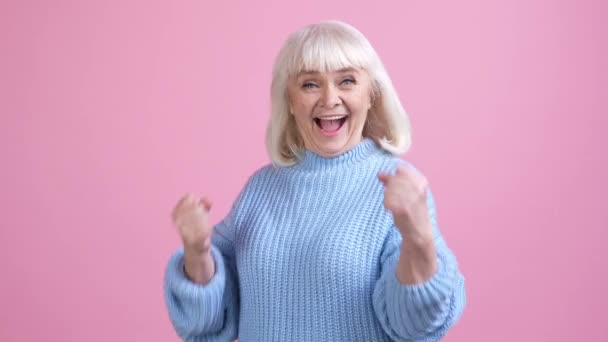 Anciana regocijarse puño arriba apuesta juego aislado pastel color fondo — Vídeo de stock