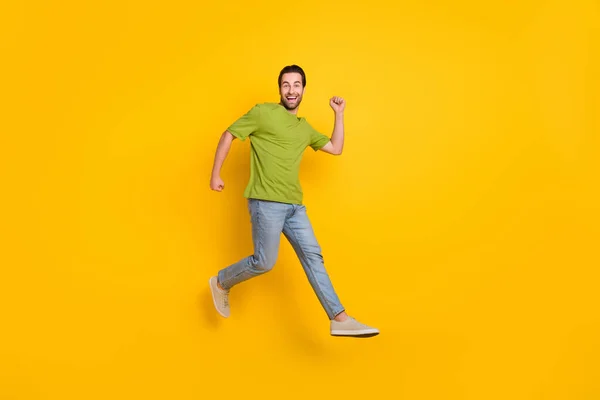 Foto lateral de perfil de tamaño completo de chico joven de buen humor corredor de movimiento activo salto rápido aislado sobre fondo de color amarillo —  Fotos de Stock