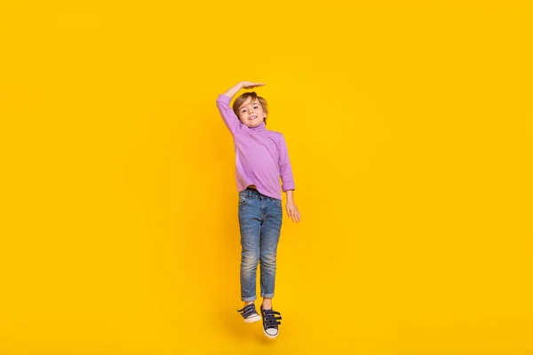 Photo pleine grandeur de joyeux petit garçon mignon sautant rêvant de devenir plus grand isolé sur fond de couleur jaune — Photo