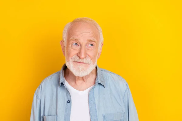 Portrait of attractive bewildered suspicious cheerful grey-haired man deciding isolated over bright yellow color background — Stock Photo, Image