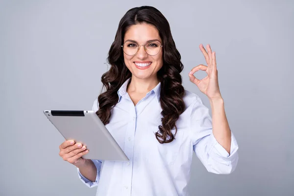 Photo of successful ceo lady hold tablet show okey znak dobre połączenie zużycie specs niebieska koszula odizolowany szary kolor tło — Zdjęcie stockowe