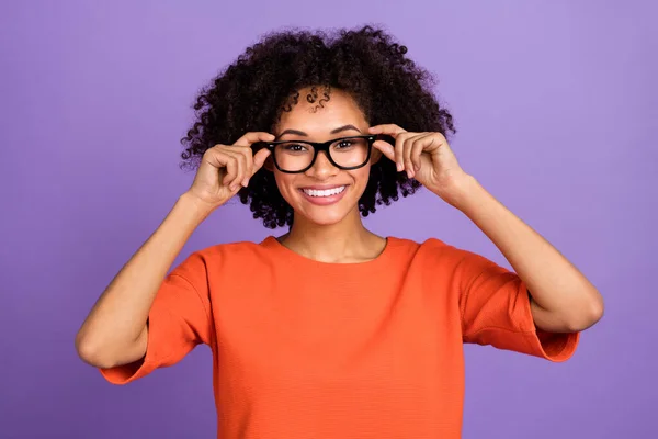 Foto de linda jovem senhora usar óculos camiseta laranja isolada no fundo cor violeta — Fotografia de Stock