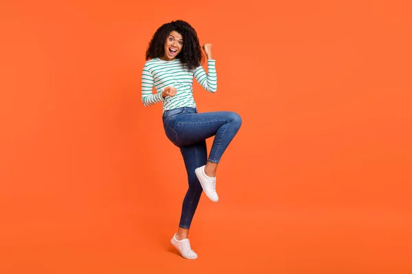 Foto de tamaño completo de las zapatillas vaqueras de la camisa de señora joven aisladas sobre fondo naranja —  Fotos de Stock