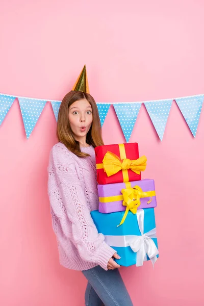 Pionowe zdjęcie funky szokujące dziewczyna ubrana z dzianiny pullover headwear gospodarstwa ciężkie prezenty stos odizolowany różowy kolor tło — Zdjęcie stockowe
