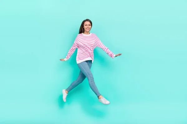 Vista completa del tamaño del cuerpo de la atractiva chica agradable alegre saltando paseando aislado sobre fondo de color turquesa verde azulado brillante — Foto de Stock