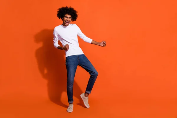 Foto de cara encantador doce usar camisa branca dançando sorrindo espaço vazio isolado cor de laranja fundo — Fotografia de Stock