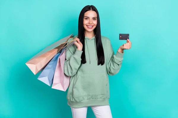 Photo of lovely millennial brunette lady hold bags card wear green pullover isolated on teal color background — Stock Photo, Image