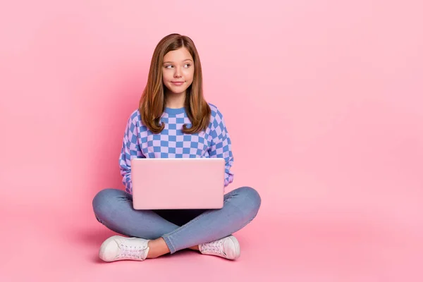 Pełny rozmiar zdjęcie brązowe włosy mała dziewczyna trzymać laptop wygląd promo nosić dżinsy sweter buty izolowane na różowym tle — Zdjęcie stockowe