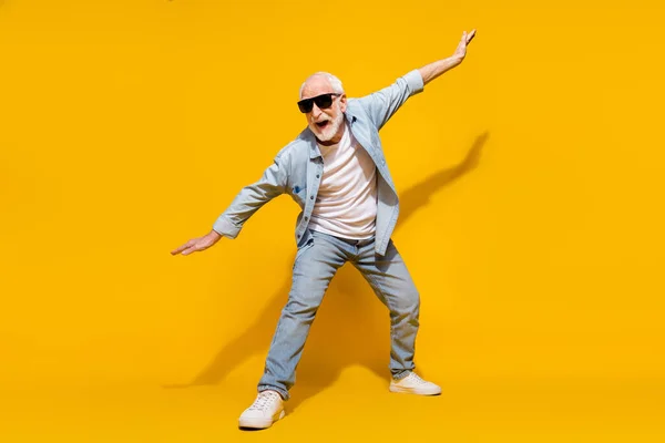 Full length body size view of attractive cheerful crazy grey-haired man having fun fooling wings isolated on bright yellow color background — Stock Photo, Image