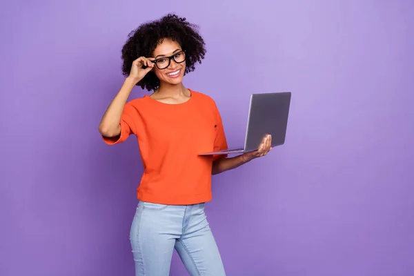 Foto de senhora morena bastante milenar segurar laptop usar óculos camiseta isolada no fundo roxo — Fotografia de Stock