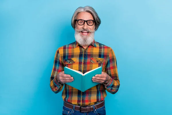 Foto de hombre jubilado emocionado vestido a cuadros gafas de camisa leyendo hechos interesantes aislado fondo de color azul — Foto de Stock