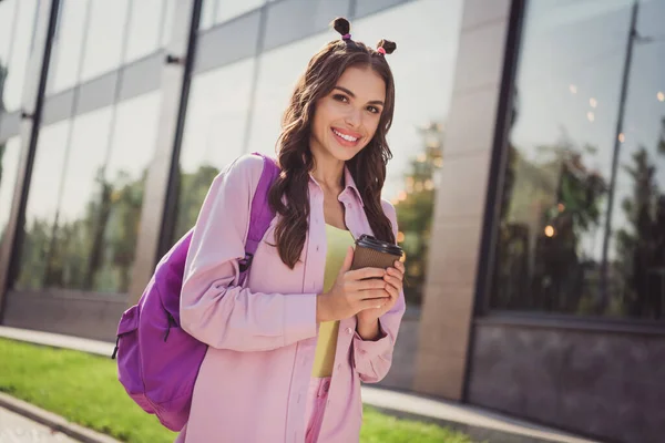 Retrato de atraente alegre menina de cabelos ondulados beber latte indo para a faculdade do ensino médio ao ar livre — Fotografia de Stock