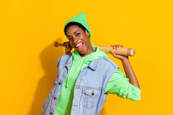 Porträtt av attraktiv glad flicka innehav bat har roligt gott humör sport isolerad över ljust gul färg bakgrund — Stockfoto