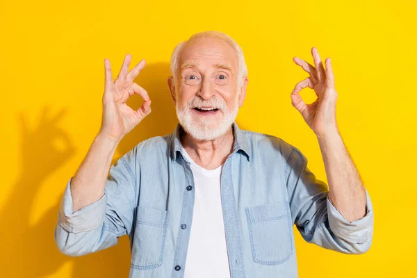 Portret van aantrekkelijke vrolijke grijs-harige man tonen dubbele ok-teken eens deal gedaan geïsoleerd over helder gele kleur achtergrond — Stockfoto