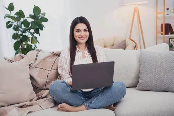 Porträtt av attraktiv glad långhårig kvinna sitter på divan med bärbar dator titta på film hemma — Stockfoto