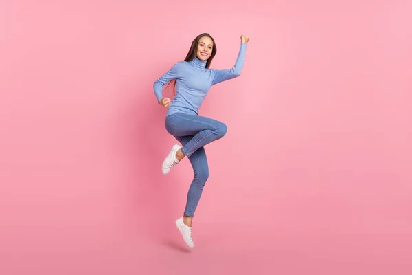 Фото божевільної тріумфальної леді стрибок святкувати перемогу підняти кулаки носити синій черепаха ізольований рожевий кольоровий фон — стокове фото