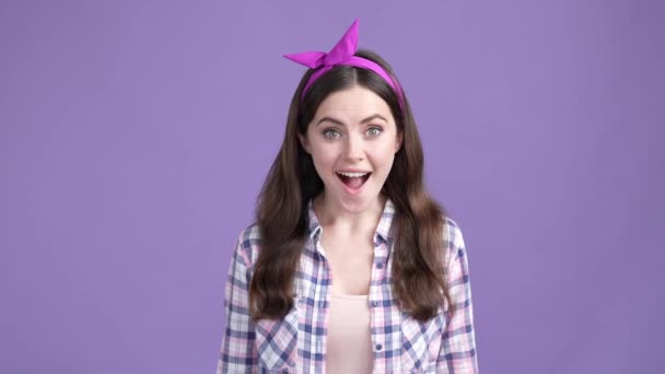 긍정적 인 여성은 자신의 세련 된 액세서리를 밝은 색 배경으로 지적한다 — 비디오