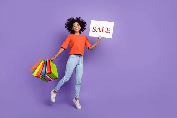 明るい魅力的な女の子消費者ホールド販売プラカードの完全な体の写真行くショッピングバイオレット色の背景に孤立 — ストック写真