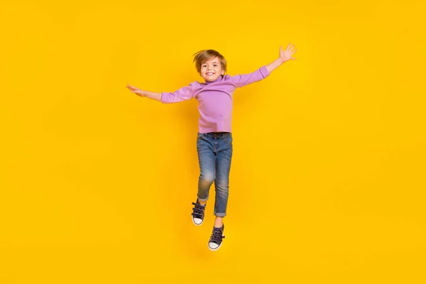 Full size foto di allegro giocoso affascinante ragazzo saltando in attesa vacanza estiva isolato su sfondo di colore giallo — Foto Stock