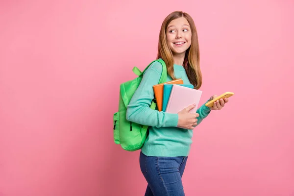Foto van dromerige school meisje gekleed teal pullover met voorraden gadget lege ruimte geïsoleerde roze kleur achtergrond — Stockfoto