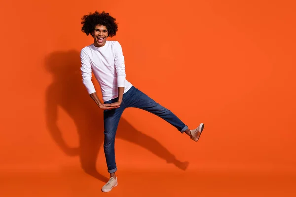 Photo of attractive pretty guy dressed white shirt smiling dancing isolated orange color background