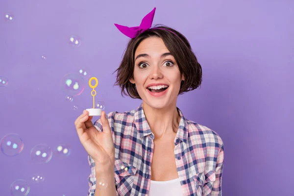 Fotografie mladé veselá hezká žena bavit moucha mýdlo bubliny izolované přes fialové barvy pozadí — Stock fotografie