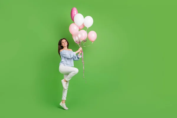 기분 이 좋은 귀여운 여성의 전체 크기 사진, 생일 선물로 녹색 배경에 고립된 귀여운 핑크 풍선 — 스톡 사진