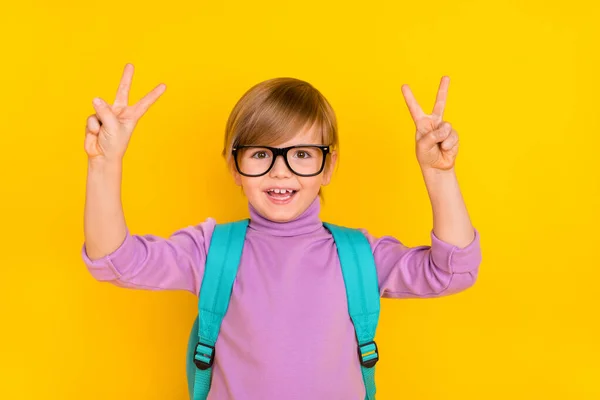 Портрет милого мальчика, показывающего V-знак счастливый пойти в школу 1 сентября первый день изолирован на желтом фоне цвета — стоковое фото