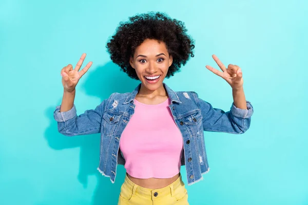 Foto di cute eccitata giovane donna indossare giacca jeans che mostra v-segni sorridente isolato sfondo di colore turchese — Foto Stock