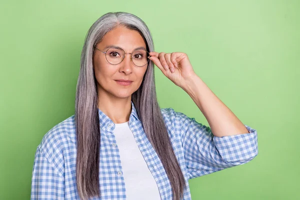Fénykép a szigorú idősebb szürke frizura hölgy visel szemüveg kék ing elszigetelt zöld színű háttér — Stock Fotó