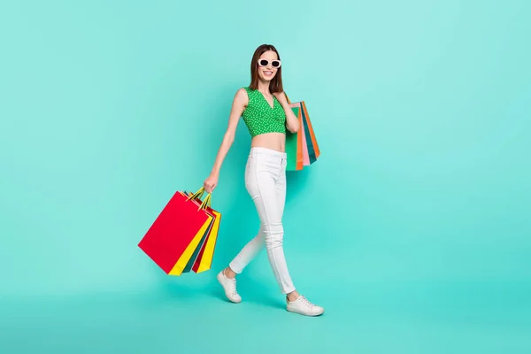 Повнорозмірна фотографія профілю молодої чарівної дівчини, що гуляє, тримає сумки зі знижкою магазин ізольований на кольоровому фоні — стокове фото