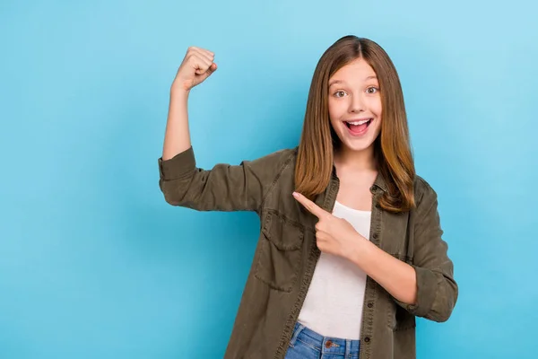 Retrato de bastante adolescente super héroe chica levantar puño en la victoria éxito punto de triunfo dedo bíceps aislado sobre fondo de color azul — Foto de Stock