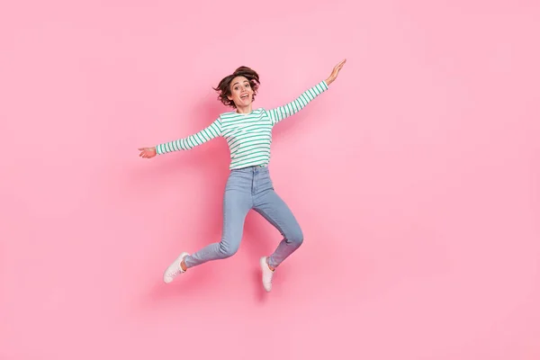 분홍빛 파스텔 색깔 배경 위에 고립된 기분좋게 뛰어다니는 매력적 인 쾌활 한 여자 아이의 전체 몸길이의 모습 — 스톡 사진