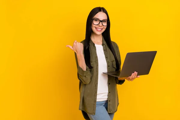 Foto do gerente milenar senhora segurar laptop índice promo desgaste eyewear camisola cáqui isolado no fundo amarelo — Fotografia de Stock
