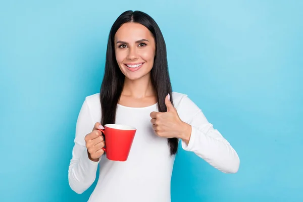 Foto de menina alegre jovem mostrar polegar-up aprovar bom seleto anúncio cappuccino isolado sobre fundo de cor azul — Fotografia de Stock