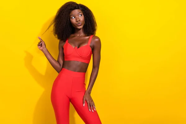 Fotografie okouzlující snivé afro dívka nosit červené sexy outfit rameno curl rty trucoval při pohledu prázdný prostor izolované žluté barvy pozadí — Stock fotografie